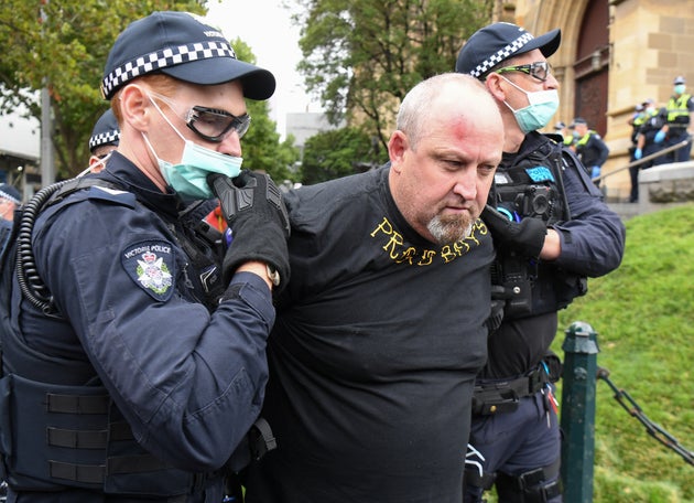 Police detain a man wearing a Proud Boys shirt after confronting protesters as thousands of people attend an Australia Day protest in Melbourne in January 26, 2021.