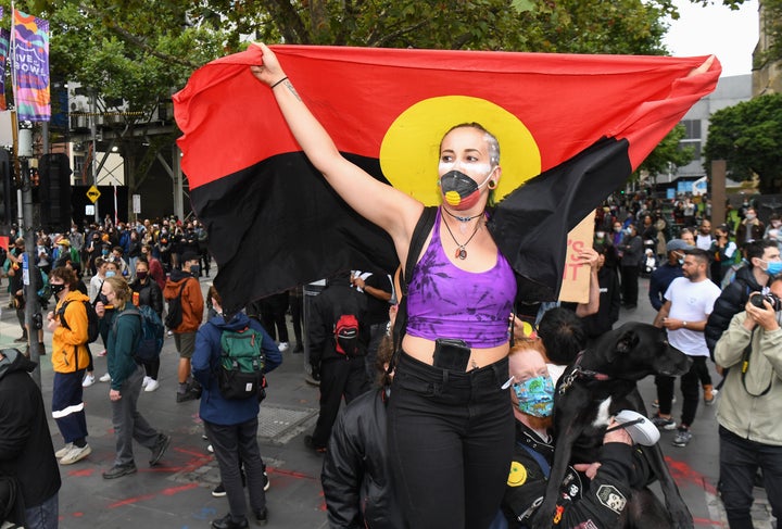 People hold placards as thousands of people attend an Australia Day protest in Melbourne in January 26, 2021. 