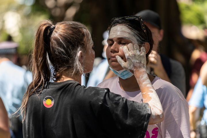 Vanessa Turnbull-Roberts (L) applies face paint to a fellow protestor during the Invasion Day rally on January 26, 2021 in Sydney, Australia. 