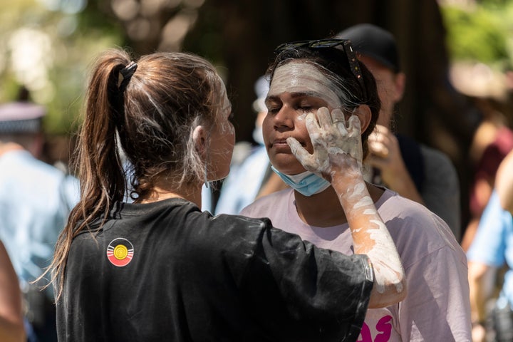 Vanessa Turnbull-Roberts (L) applies face paint to a fellow protestor during the Invasion Day rally on January 26, 2021 in Sydney, Australia. 