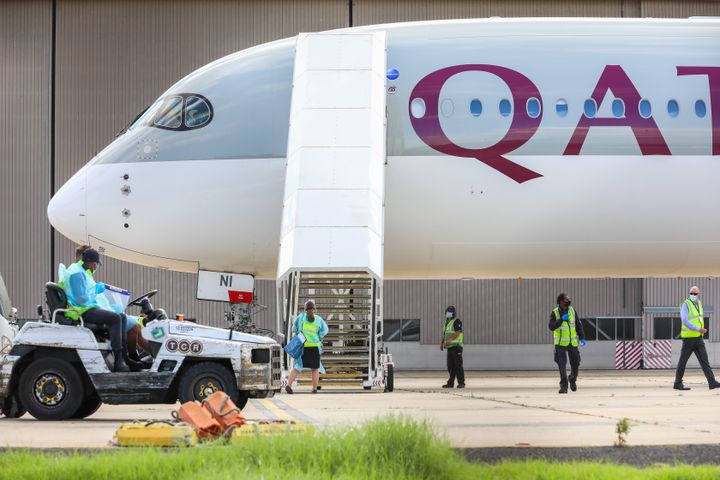 Biosecurity and airport staff in PPE and masks surround a chartered flight at Melbourne carrying players and staff for the Australian Open tennis tournament.