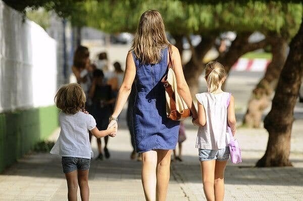 Una madre pasea con sus hijos.