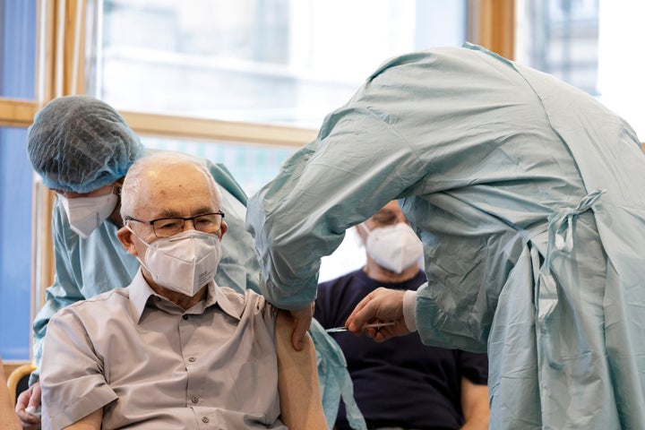 A Holocaust survivor receives the COVID-19 vaccine from Health Minister Marek Krajci, right, on International Holocaust Remembrance Day in Bratislava, Slovakia, Wednesday, Jan. 27, 2021.