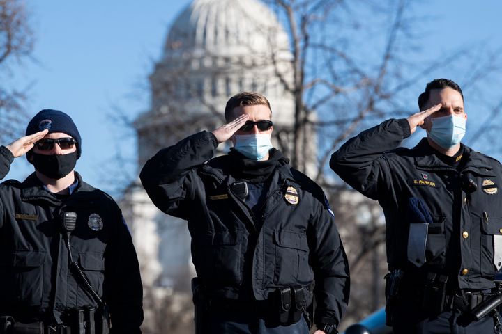 U.S. Capitol Police officers salute as the hearse carrying the body of their colleague, Officer Brian Sicknick, passes by in Washington on Jan. 10. Sicknick, 42, died from injuries suffered in the Jan. 6 attack on the U.S. Capitol that followed a rally headlined by then-President Donald Trump.