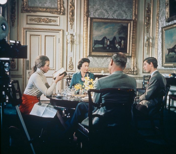 Queen Elizabeth II lunches with Prince Philip, Princess Anne and Prince Charles at Windsor Castle, circa 1969. A camera (left) is set up to film for Richard Cawston's BBC documentary "Royal Family." 