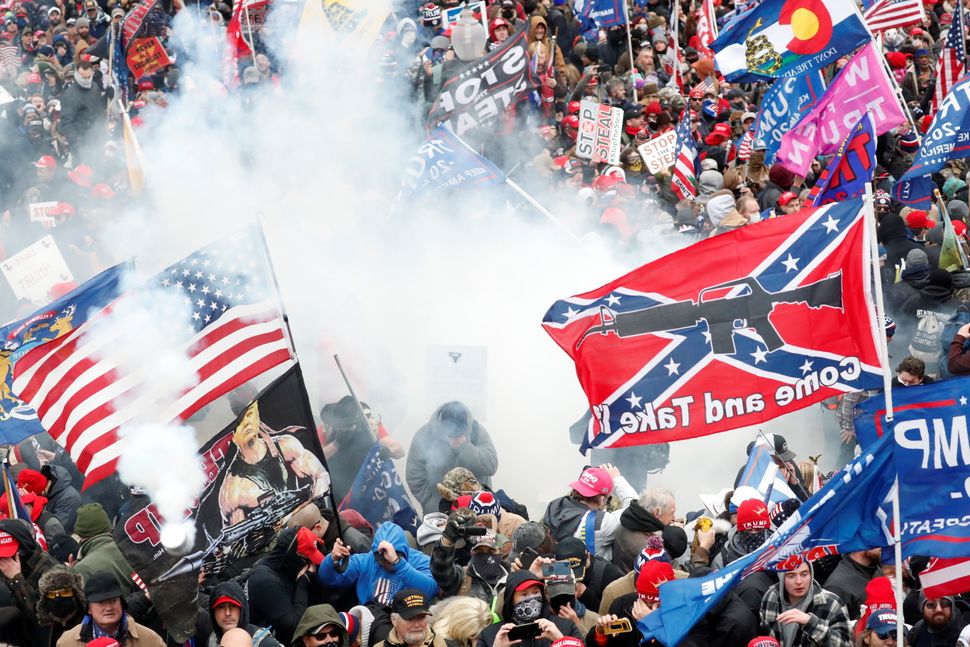 Tear gas is released into a crowd of protesters, with one wielding a Confederate battle flag that reads "Come and Take It," d