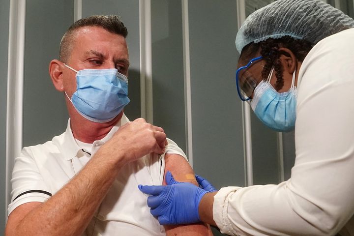 Nurse Mark Carey gets a bandage after he receives a vaccination at Mt. Sinai Hospital, New York City, on Dec. 15, 2020.