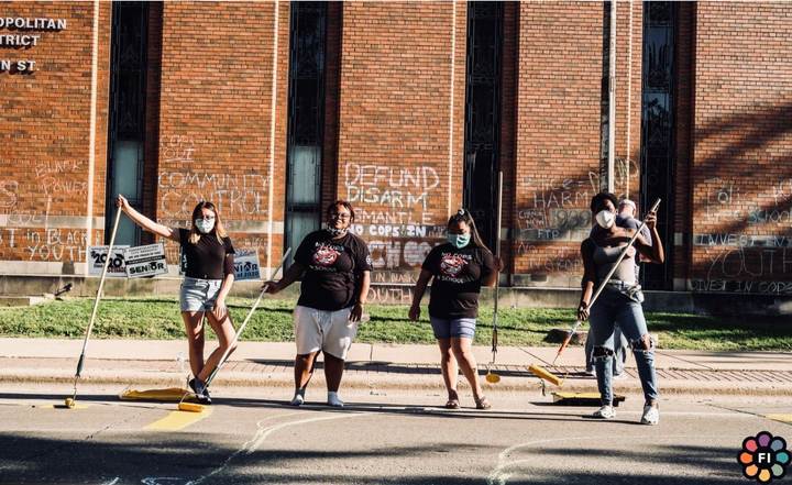 Adams (second from left) and members of the Freedom Youth Squad painted “Police free schools” on the road in front of the Madison Metropolitan School District administrative building in June. For five years, Adams testified at meetings of the school board in an effort to have armed officers removed from Madison high schools.