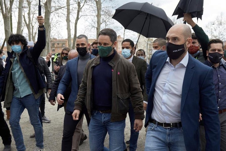 Abascal llega al acto protegido por paraguas ante el lanzamiento de grava.