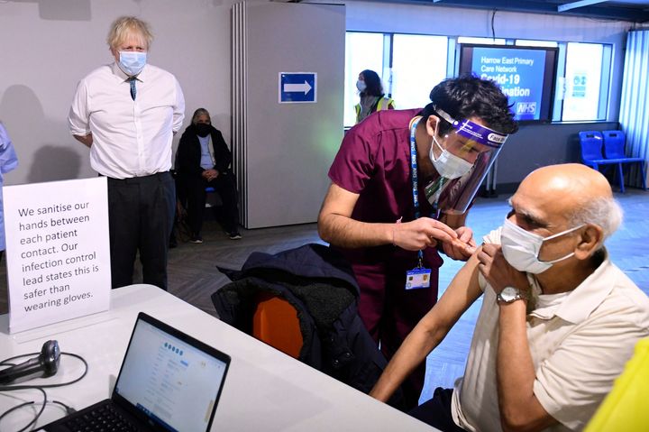 Boris Johnson watches a patient receiving a dose of the Oxford/Astrazeneca coronavirus vaccine, during a visit to Barnet FC's ground at the Hive, earlier this month.