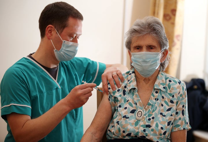 Dr Maurice Price administers the BioNTech/Pfizer Covid-19 vaccine into the arm of Beryl Humphreys, a resident at Bowbrook House care home in Shrewsbury on January 20