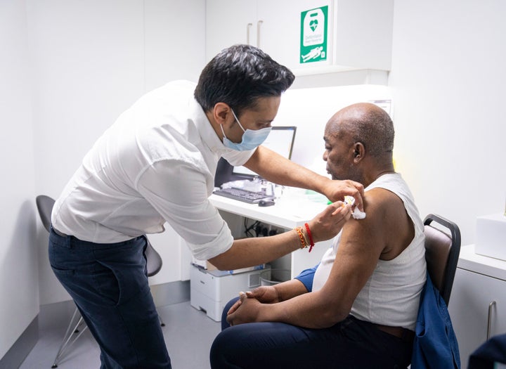 Pharmacist Bhaveen Patel administers a dose of the Oxford/AstraZeneca covid vaccine to Joshua Labor at a coronavirus vaccination clinic held at Junction Pharmacy in Brixton, London.