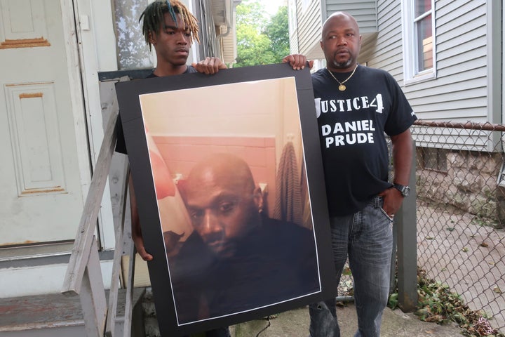 Daniel Prude's nephew, Armin (left), and his uncle, Joe Prude, hold a photo of Daniel.