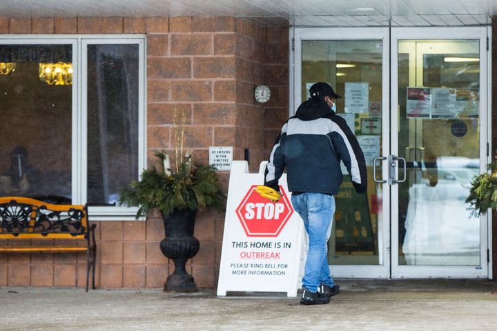 A man wearing a face mask enters Roberta Place in Barrie, Ont., on Jan. 21, 2021. The home, owned by Jarlette health Services, is at the centre of a class-action lawsuit for its handling of a devastating COVID-19 outbreak.