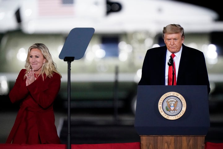 Rep. Marjorie Taylor Greene smiles as then-President Donald Trump speaks at a rally in Dalton, Georgia, on Jan. 4, 2021.