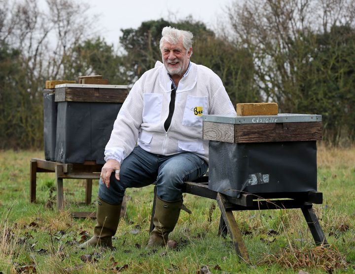 Murfet sits amongst some of his hives in an orchard near Canterbury in Kent