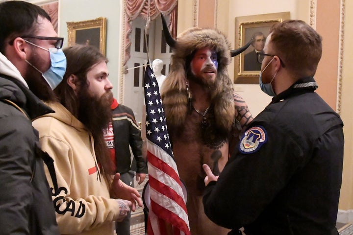 Jacob Anthony Chansley, also known as Jake Angeli, of Arizona speaks with a U.S. Capitol Police officer after supporters of then-President Donald Trump occupied the Capitol in Washington, U.S., January 6, 2021. (REUTERS/Mike Theiler)