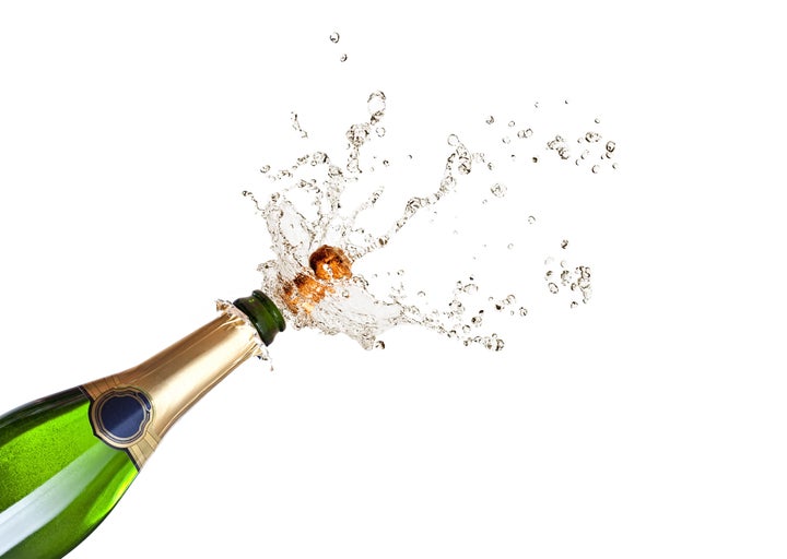 detail of popping champagne on black background