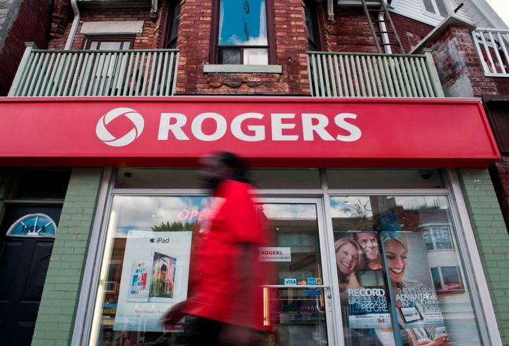 A pedestrian walks by a Rogers store on Dundas Street West in Toronto on Aug. 15, 2013. 