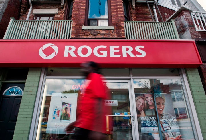 A pedestrian walks by a Rogers store on Dundas Street West in Toronto on Aug. 15, 2013. 