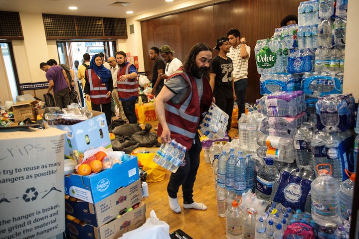 Volunteers sort through donations for victims at the Al Manaar Muslim Cultural Centre near to the site of the Grenfell Tower fire on June 15, 2017 