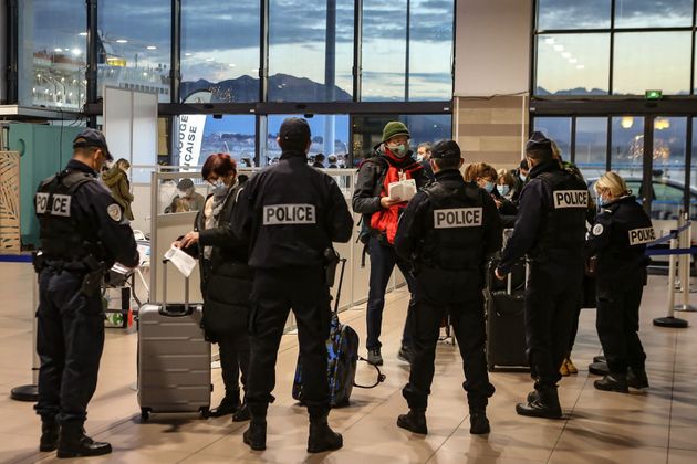 Un test PCR obligatoire pour aller en Corse, les tests antigéniques ne seront plus acceptés (Photo d'illustration: des agents de police contrôlant des passagers arrivés en Corse en décembre au port d'Ajaccio. Par PASCAL POCHARD-CASABIANCA/AFP via Getty Images)