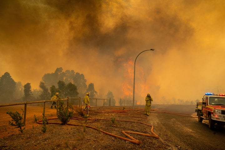 Firefighters set up hoses and equipment in Wooroloo on February 2 in Perth, Australia.