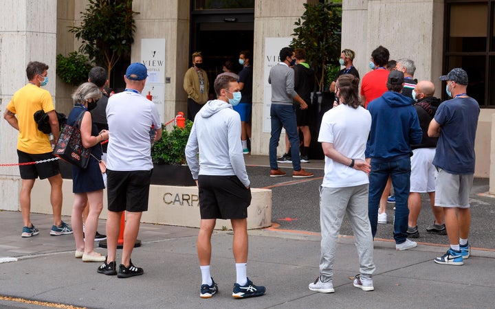 Tennis players queue for a Covid-19 coronavirus test at a hotel in Melbourne on February 4, 2021, as six Australian Open warm-up events were on hold and hundreds of players and officials in isolation as a fresh coronavirus case left organisers scrambling to ensure the Grand Slam tennis tournament goes ahead.