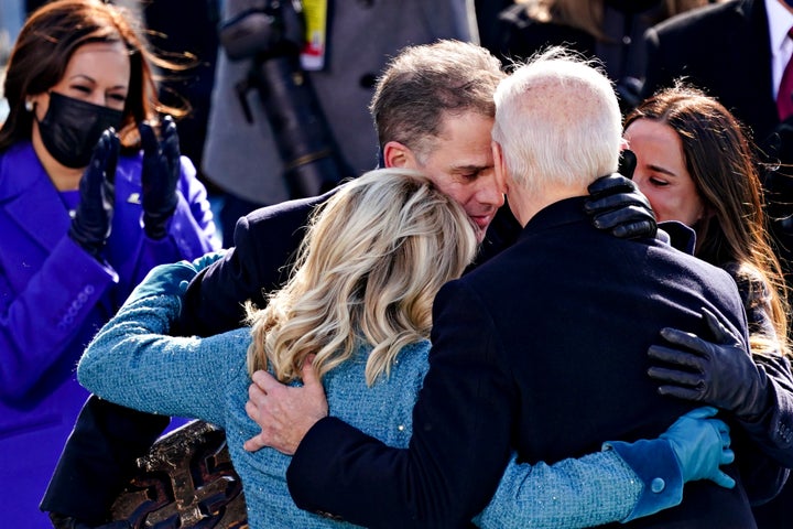 President Joe Biden, right, is comforted by his son Hunter Biden and First Lady Jill Biden after being sworn in during the in