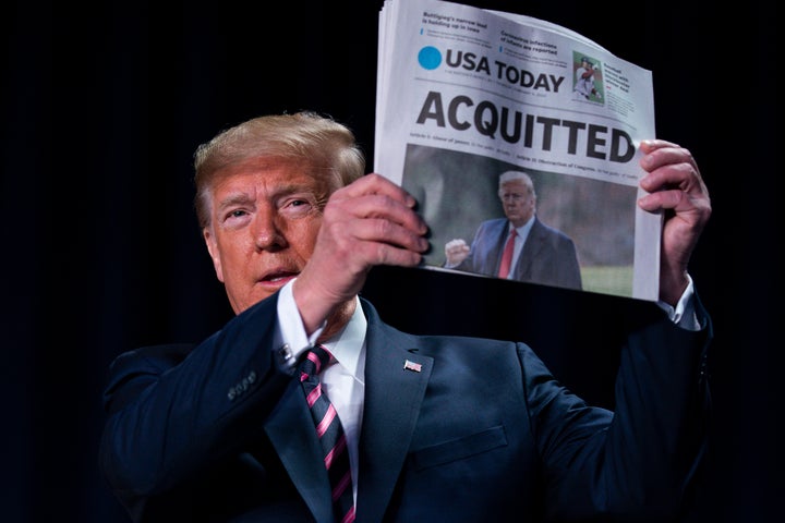 President Donald Trump holds up a newspaper with the headline that reads "ACQUITTED" at the 68th annual National Prayer Break