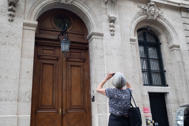 A pedestrian stops to take a photo of Jeffrey Epstein's townhouse on the Upper East Side of Manhattan. The Epstein Victi