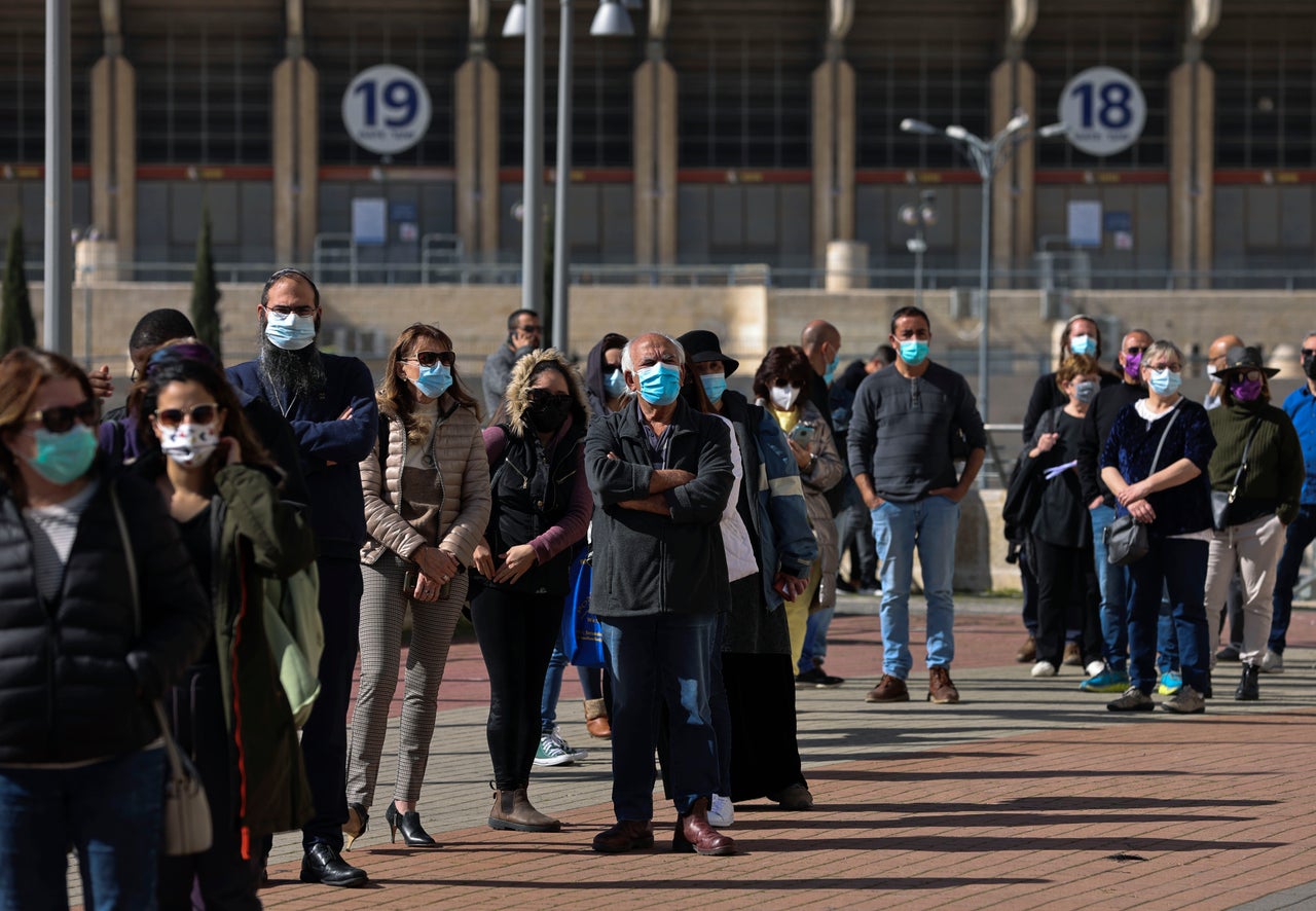 People wait in a queue to receive a dose of the Pfizer-BioNtech vaccine in Jerusalem.