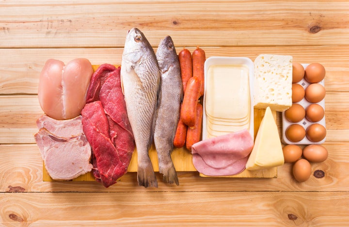 Group of important proteins, meats, fish, dairy, eggs, white meat on a wooden table as background, Shot from above