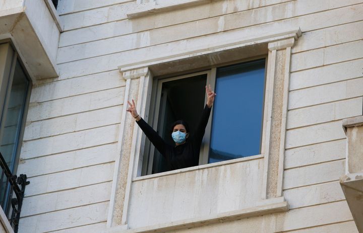 .A woman who is in quarantine gestures from a window at a hotel in Beirut