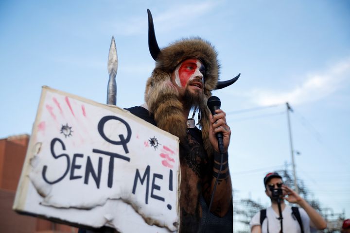 A man holding a sign referencing QAnon speaks as supporters of U.S. President Donald Trump gather to protest about the early results of the 2020 presidential election, in front of the Maricopa County Tabulation and Election Center (MCTEC), in Phoenix, Arizona November 5, 2020. REUTERS/Cheney Orr