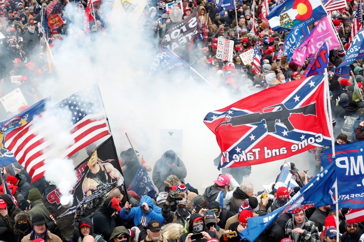 Tear gas is released into a crowd of protesters, with one wielding a Confederate battle flag that reads "Come and Take It," during clashes with Capitol police at a rally to contest the certification of the 2020 U.S. presidential election results on Jan. 6, 2021. 