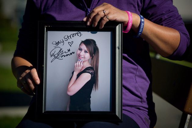 Carol Todd holds a photograph of her late daughter Amanda Todd signed by U.S. singer Demi Lovato with...