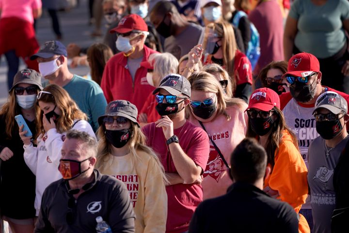 People wait in line for an exhibit at the NFL Experience Thursday, Feb. 4, 2021, in Tampa, Fla. The city is hosting Sunday's Super Bowl football game between the Tampa Bay Buccaneers and the Kansas City Chiefs. (AP Photo/Charlie Riedel)