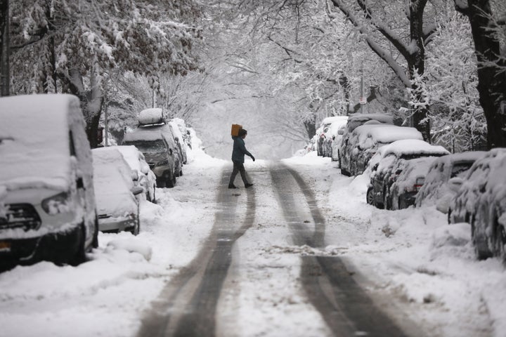 A person walks along the street during a snowstorm in New York City on Sunday. The region is experiencing its second maj