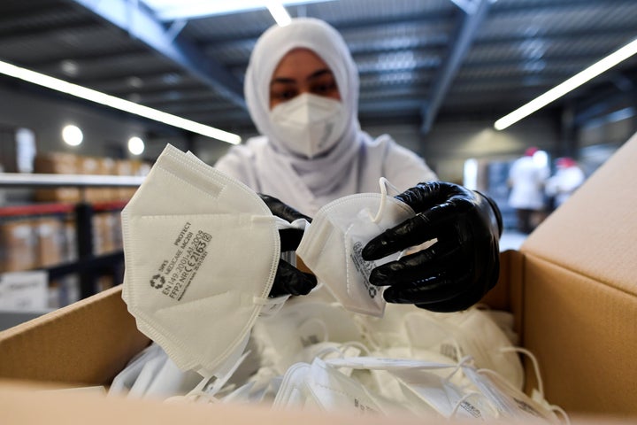 Un empleado empaqueta mascarillas FFP2.