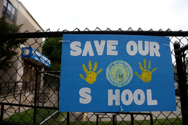 A sign made by parents and students of Queen of the Rosary Catholic Academy hangs on the fence outside the school in Brooklyn