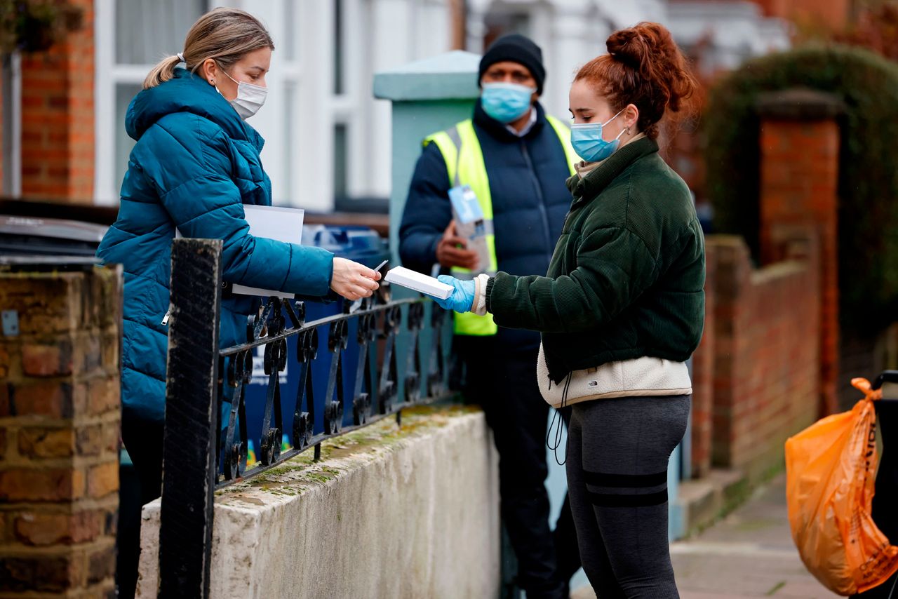 A local resident seals their completed coronavirus test kit to give to a volunteer in West Ealing, where surge testing has been taking place.