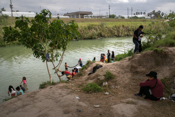 Asylum-seekers wash clothes on the Mexican side of the Rio Grande.