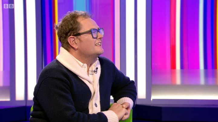 Alan Carr listens politely while being thanked for his work in the world of interior design.