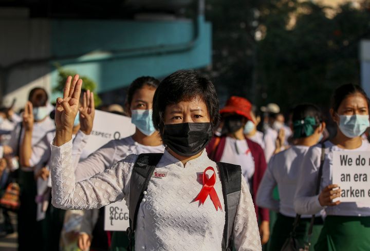 School teachers dressed in their school uniforms flash three-finger salute, a symbol of resistance during a protest in Yangon, Myanmar, on Feb. 9, 2021.