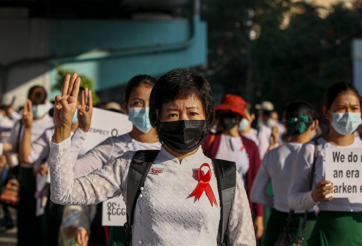 School teachers dressed in their school uniforms flash three-finger salute, a symbol of resistance during a protest in Yangon