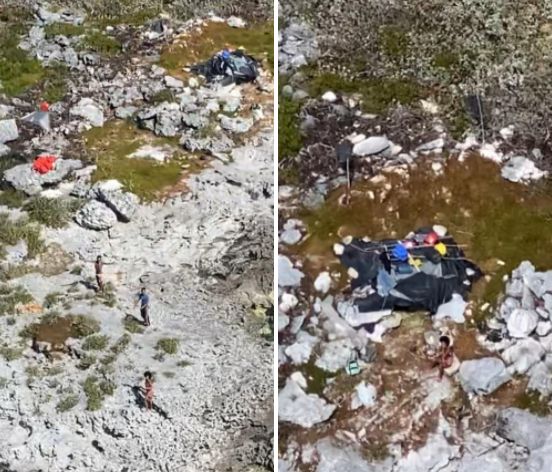 The three people are seen in photos taken by the U.S. Coast Guard on Monday. Food, water and other supplies were dropped down to them with a parachute until they could be safely evacuated.