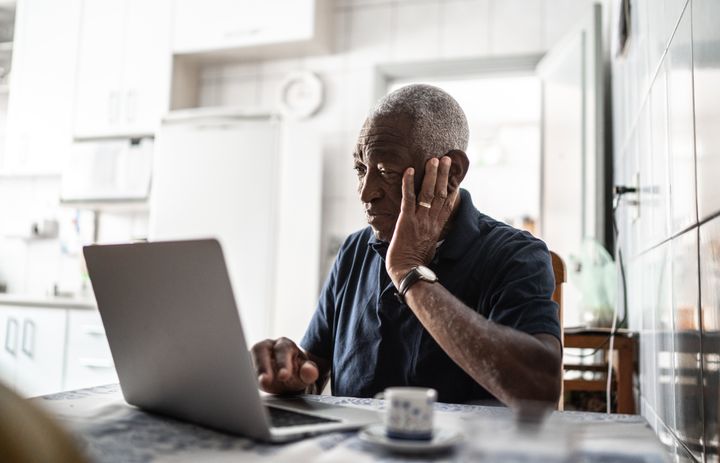 Senior man worried working at laptop