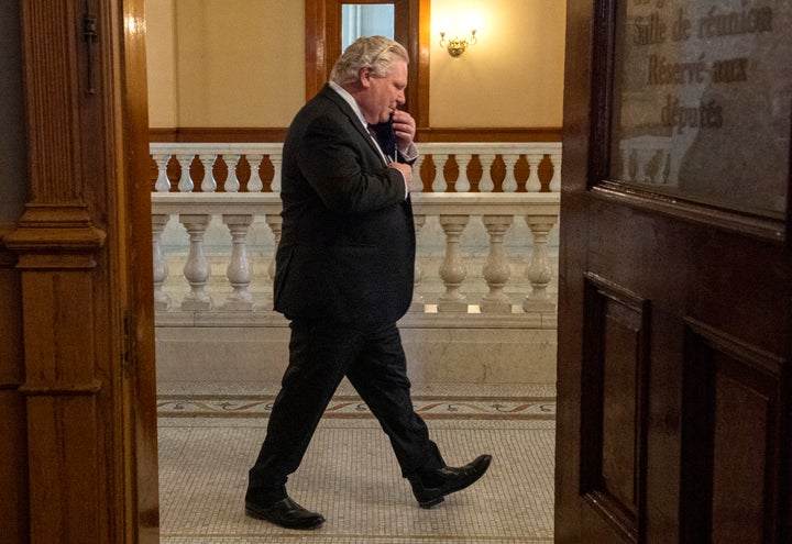 Ontario Premier Doug Ford walks past an open door as he arrives for the daily briefing in Toronto on Feb. 8, 2021.