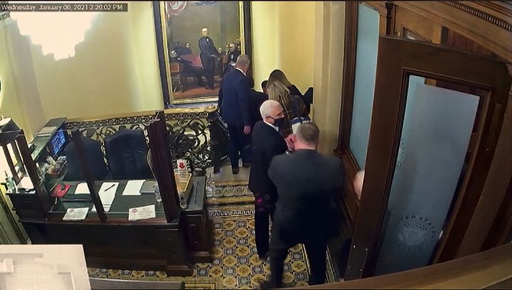 In this image shown Wednesday from a Senate video, a security camera shows Vice President Mike Pence being evacuated as rioters breach the U.S. Capitol